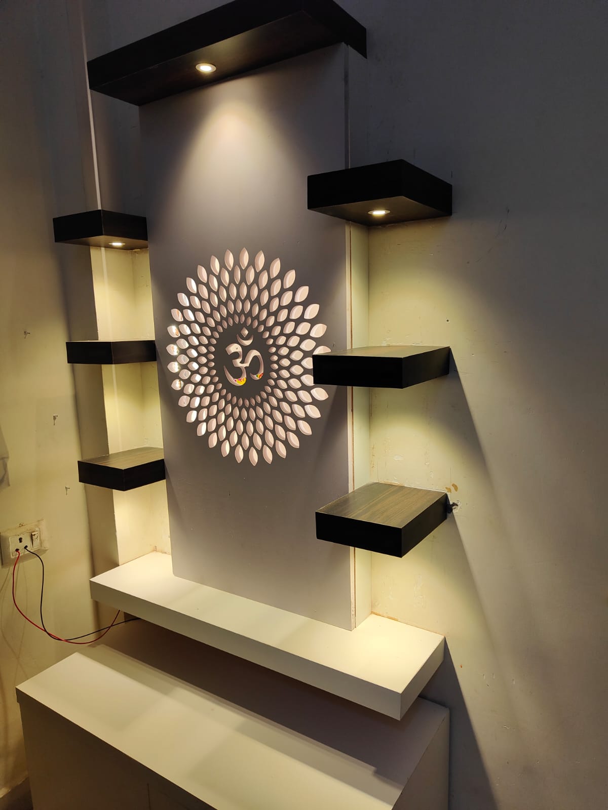 Decorative wall shelves with Om backlit motif